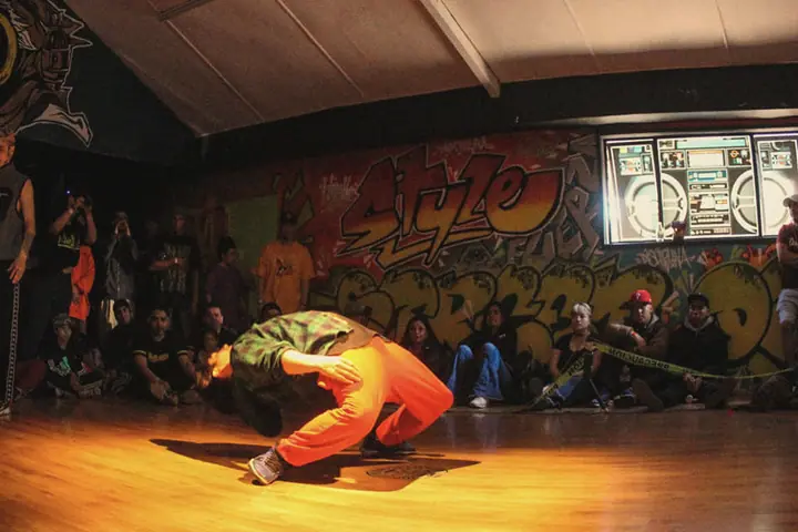Un bboy en un freeze bajo la luz cálida de la pista