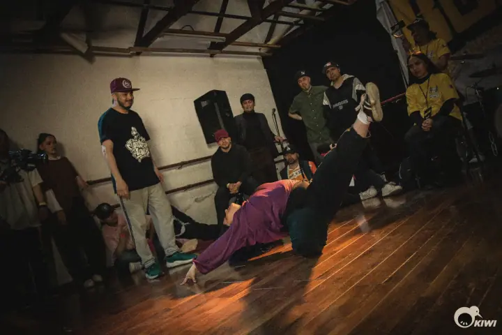 Un bailarín congelado en el piso mientras la ronda mira